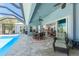 Inviting outdoor patio with pool, seating and dining areas, seamlessly blending indoor and outdoor living spaces at 228 White Marsh Ln, Rotonda West, FL 33947