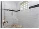 Bathroom featuring an all-tile shower with a tiled bench and a glass block window at 228 White Marsh Ln, Rotonda West, FL 33947