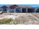 Under construction house with front door and two-car garage on a sunny day at 254 White Marsh Ln, Rotonda West, FL 33947