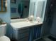 Cozy bathroom with white toilet, sink, vanity with drawers, and blue accents at 26191 Angelica Rd, Punta Gorda, FL 33955