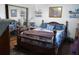 Cozy bedroom featuring a wooden bed frame, soft bedding, and a mirrored closet at 26191 Angelica Rd, Punta Gorda, FL 33955