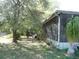 Enclosed patio in the backyard surrounded by trees and grass at 26191 Angelica Rd, Punta Gorda, FL 33955