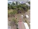 Aerial view of lot with mature trees, shed, and partial rooftop with red cover at 3021 Holly Ave, Englewood, FL 34224