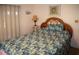 Bedroom with a rattan headboard, a tropical-themed bedspread, and soft natural light at 3021 Holly Ave, Englewood, FL 34224