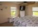 Bright bedroom features two windows, a TV, and a comfortable bed, creating a relaxing space at 3021 Holly Ave, Englewood, FL 34224