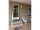 Home entryway with stone steps, welcome mat, and adjacent seating, with a screened-in patio door at 3021 Holly Ave, Englewood, FL 34224