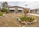 Tan home with tidy front lawn and landscaped flowerbed with a sign reading 'Spring' at 3021 Holly Ave, Englewood, FL 34224