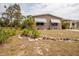 Tan home featuring tidy front lawn, landscaping and stone bordered flower bed at 3021 Holly Ave, Englewood, FL 34224