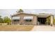 Tan home with a covered carport and awning-covered windows complemented by small decorative pineapples on the lawn at 3021 Holly Ave, Englewood, FL 34224