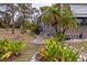 Home exterior with attractive landscaping featuring palms, decorative rocks, and an ADT security sign at 3021 Holly Ave, Englewood, FL 34224