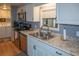 Kitchen with stainless steel appliances, modern faucet, and white cabinets at 3021 Holly Ave, Englewood, FL 34224