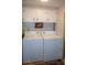 Bright laundry room with white washer, dryer, and plenty of storage space at 3021 Holly Ave, Englewood, FL 34224