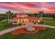 Stunning aerial view of a luxurious estate with a red tile roof, lush landscaping, and a circular driveway at 3700 Como St, Port Charlotte, FL 33948