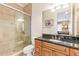 Bathroom featuring a glass-enclosed shower, granite countertops, wood cabinets, and modern fixtures at 3700 Como St, Port Charlotte, FL 33948