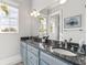 This bright bathroom has a double sink vanity and a large mirror, with a window providing natural light at 3700 Como St, Port Charlotte, FL 33948