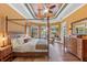 Bright main bedroom with a wood ceiling, hardwood floors, and a four poster bed with a view to the pool at 3700 Como St, Port Charlotte, FL 33948
