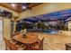 Covered patio with dining area overlooking a sparkling pool at twilight at 3700 Como St, Port Charlotte, FL 33948