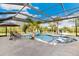 Screened-in pool featuring lounge chairs, a center palm tree, and beautiful views of the outdoors at 3700 Como St, Port Charlotte, FL 33948