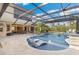 Stunning backyard pool with built-in spa, sun shelves, and covered lanai offers a luxurious outdoor living experience at 3700 Como St, Port Charlotte, FL 33948