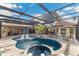 Expansive backyard with a sparkling pool, spa, and covered lanai is ideal for outdoor entertaining and relaxation at 3700 Como St, Port Charlotte, FL 33948