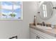 Well-lit powder room featuring a sink, a mirror, and neutral decor for a clean and refreshing space at 3700 Como St, Port Charlotte, FL 33948