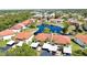 Aerial view of the community with a pond surrounded by buildings with orange roofs and green trees at 405 Pine Hollow Cir # 405, Englewood, FL 34223