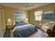 Comfortable bedroom featuring a queen bed, ceiling fan, and colorful beach themed artwork at 405 Pine Hollow Cir # 405, Englewood, FL 34223