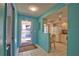 Bright entryway leads into a kitchen with white cabinets and appliances, featuring a sunny atmosphere at 405 Pine Hollow Cir # 405, Englewood, FL 34223