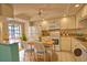 Cozy kitchen with white cabinetry, tile floor, and a dining table illuminated by natural light from the window at 405 Pine Hollow Cir # 405, Englewood, FL 34223