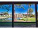 Picturesque screened-in lanai view of a serene pond and well-maintained buildings at 405 Pine Hollow Cir # 405, Englewood, FL 34223