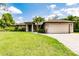 Home featuring an expansive lawn, tasteful landscaping, and a circular paver driveway at 4238 Golfair Ln, North Port, FL 34288