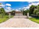 A beautiful paver driveway leads to an elegant home with decorative fencing and a manicured lawn at 4238 Golfair Ln, North Port, FL 34288