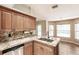 Kitchen featuring granite countertops, a stainless steel dishwasher, and a sink overlooking a bay window at 4238 Golfair Ln, North Port, FL 34288