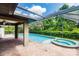 Screened-in pool with an attached jacuzzi tub and brick patio at 4238 Golfair Ln, North Port, FL 34288