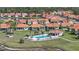 An aerial view highlights homes surrounding a community pool, complemented by a scenic pond at 4308 Summertree Rd, Venice, FL 34293