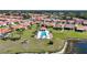 Aerial view showcases a community pool, surrounded by homes and a picturesque pond at 4308 Summertree Rd, Venice, FL 34293