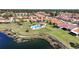 A panoramic aerial shot showcases a community pool, a serene pond, and beautiful surrounding houses at 4308 Summertree Rd, Venice, FL 34293