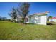Manicured lawn behind the house, complemented by lush landscaping and the privacy of mature trees at 4308 Summertree Rd, Venice, FL 34293