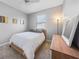 Comfortable bedroom with a queen-sized bed, dresser, and bright window at 4308 Summertree Rd, Venice, FL 34293