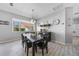 Bright dining room featuring a dark wood table set, complemented by modern lighting fixtures and elegant decor at 4308 Summertree Rd, Venice, FL 34293