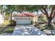 Charming single-story home with a well-maintained lawn and a red tile roof, nestled under mature shade trees at 4308 Summertree Rd, Venice, FL 34293