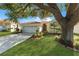 Single-story home with a well-manicured lawn, landscaping, a red tile roof, and a two car garage at 4308 Summertree Rd, Venice, FL 34293