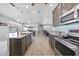 Open-concept kitchen featuring stainless steel appliances, dark wood cabinets, and an eat in island at 4308 Summertree Rd, Venice, FL 34293