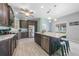 Open-concept kitchen with stainless steel appliances, dark wood cabinets, a center island, and tile floors at 4308 Summertree Rd, Venice, FL 34293