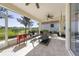 Enjoy the outdoors in this screened patio, featuring a ceiling fan and views of the manicured lawn and water at 4308 Summertree Rd, Venice, FL 34293