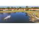 A rainbow arcing from a pond with fountain surrounded by homes on an expansive lawn at 4308 Summertree Rd, Venice, FL 34293
