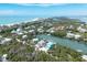 Aerial view of a coastal home with waterfront access surrounded by lush greenery and a sandy beach at 50 Tarpon Way, Placida, FL 33946