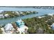 Aerial view of a turquoise waterfront home with palm trees, lush greenery, and a private driveway at 50 Tarpon Way, Placida, FL 33946