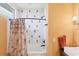 Bright bathroom featuring white tiled walls accented by decorative mosaic tiles, a shower with a palm tree shower curtain at 50 Tarpon Way, Placida, FL 33946