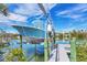 A light blue boat sits on a lift over the water on a sunny day near the dock at 50 Tarpon Way, Placida, FL 33946
